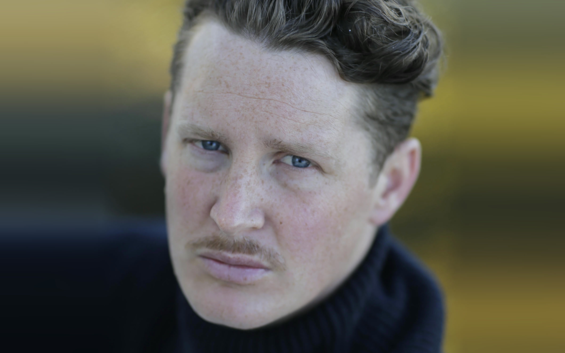 Benjamin Noble, a close portrait in a dark roll-neck